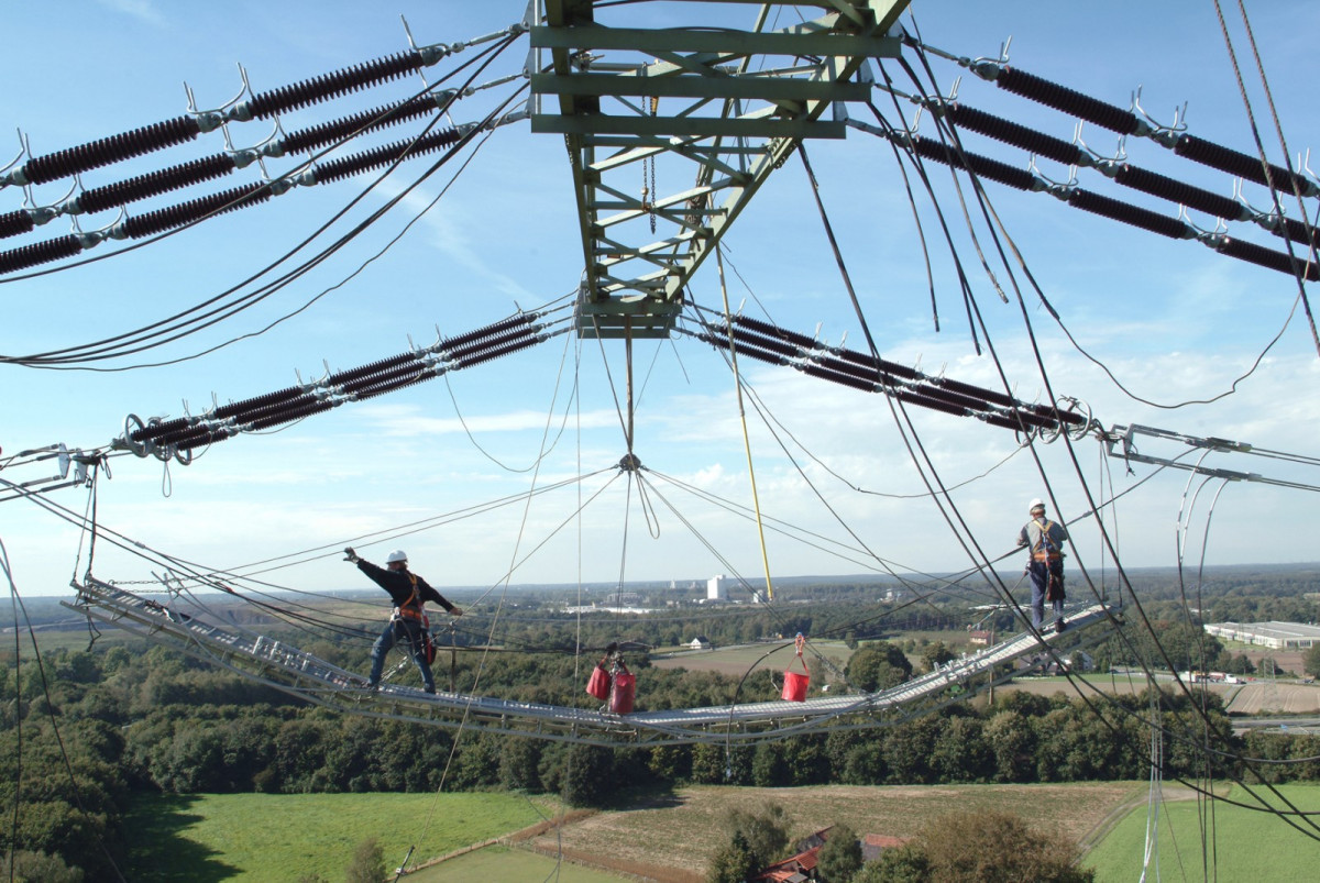 Photo shows workers constructing power grid. Source: Amprion GmbH.