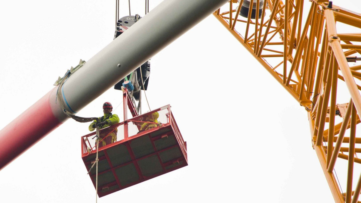 Photo shows worker on crane construction wind power turbine. Source: Bundesverband WindEnergie e.V.