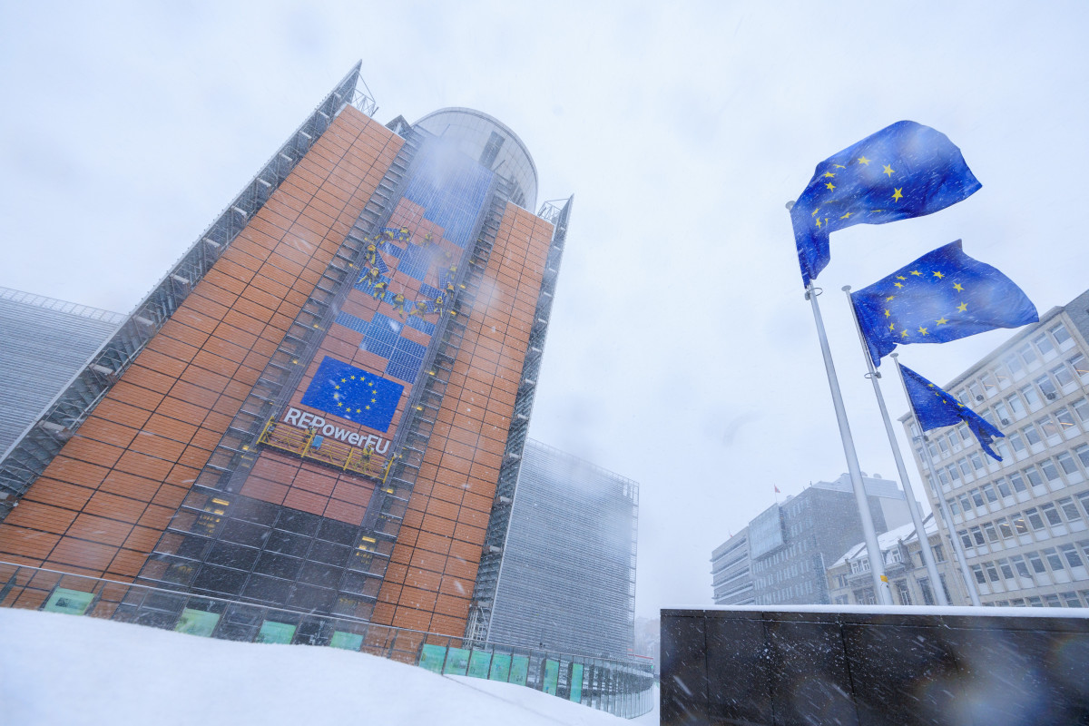 Photo shows European Commission building Berlaymont in Brusels, covered in snow, with EU flags. Photo: European Union. 