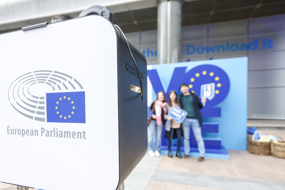 Photo shows people taking photo in front of VOTE instalment at EU elections in 2019, in Brussels. Photo: European Union 2019, Source: EP. 