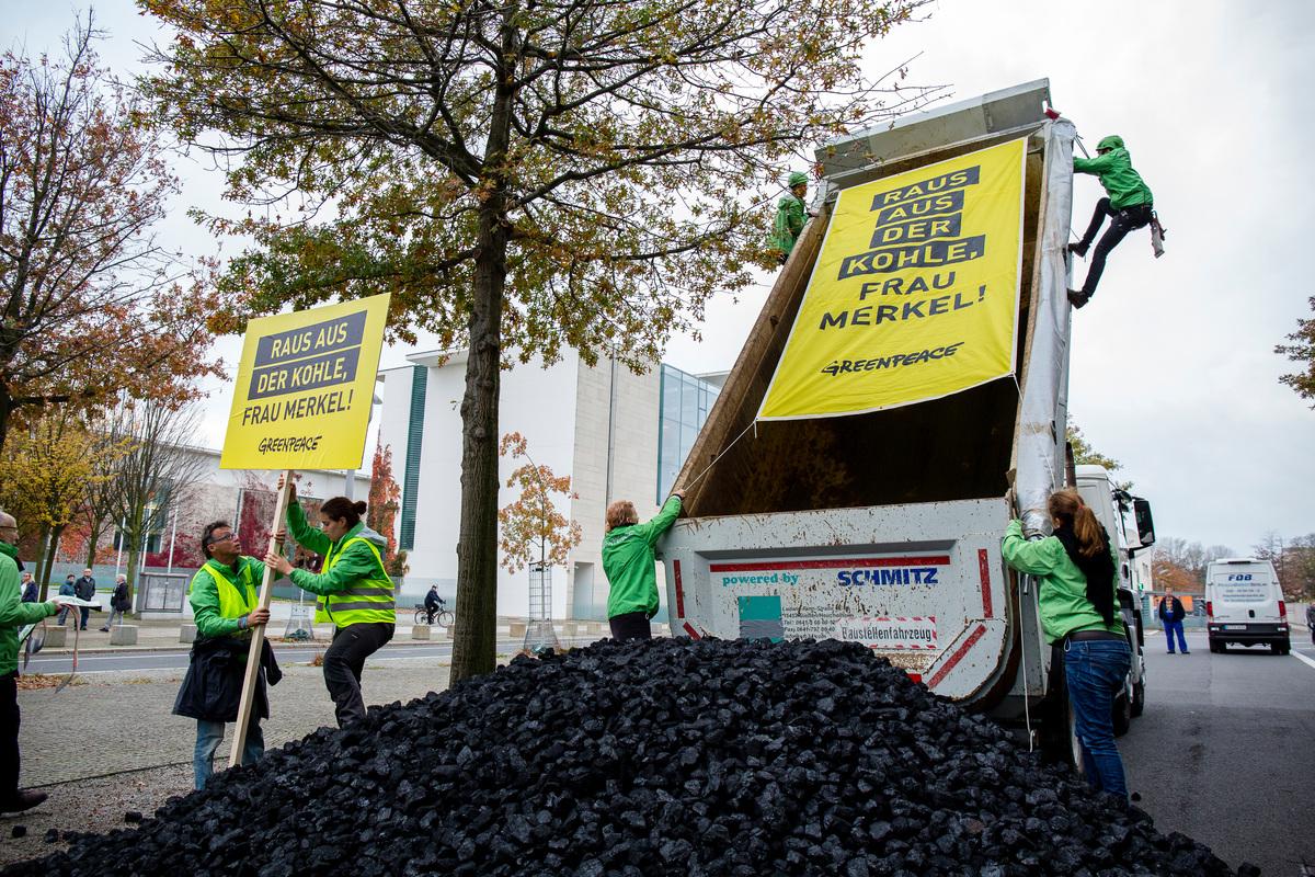 "Exit coal, Ms Merkel" - Greenpeace activists unload a truckload of coal in front of the German chancellery ahead of the coalition talks - (c) Jan Zappner/Greenpeace