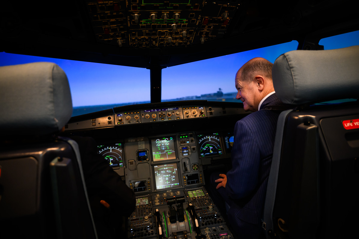 Picutre shows German chancellor Scholz in an aeroplane cockpit 