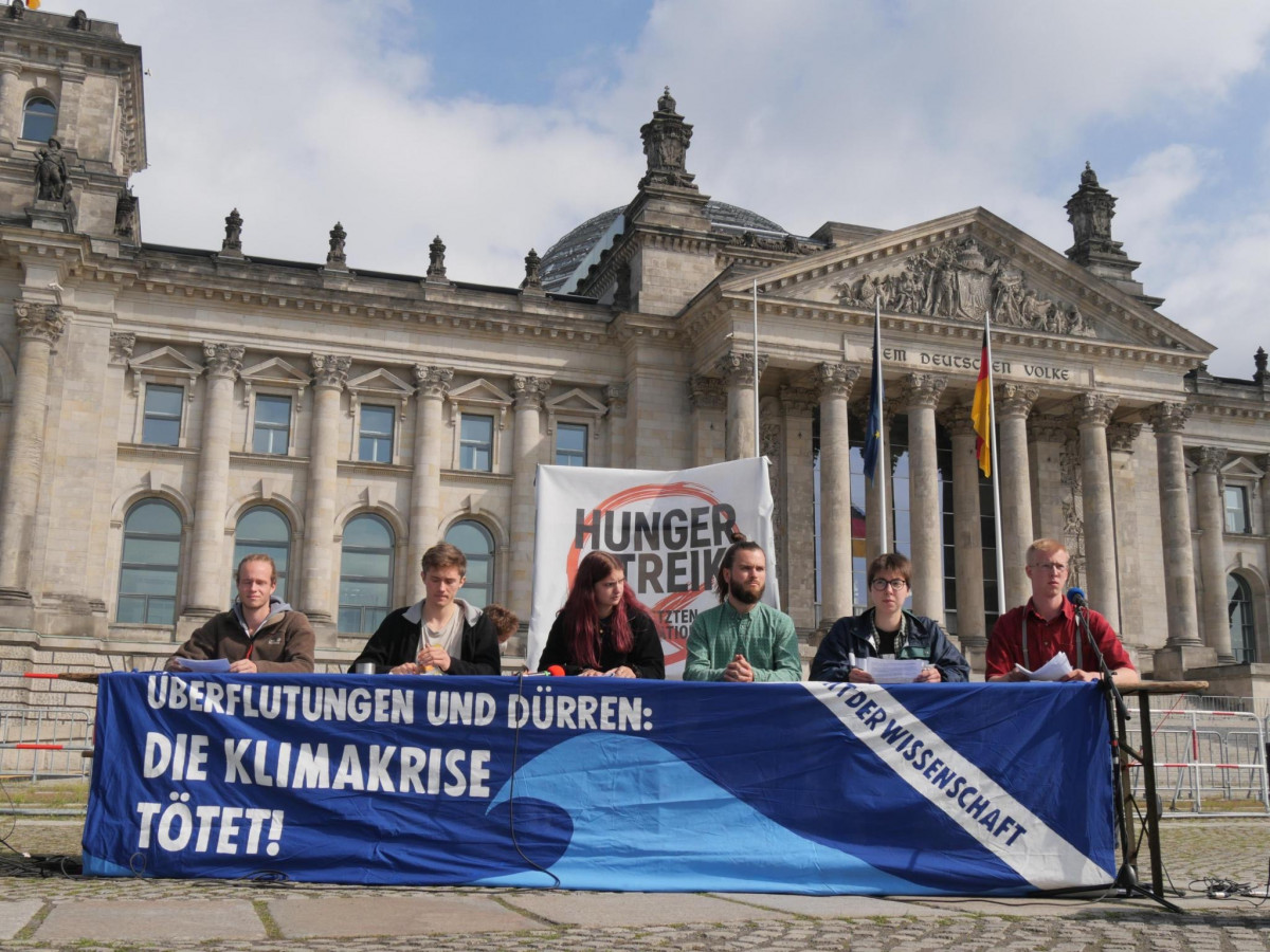 The six hunger strikers giving a press conference in front of Germany's federal parliament building in Berlin. Photo: Hungerstreik2021.